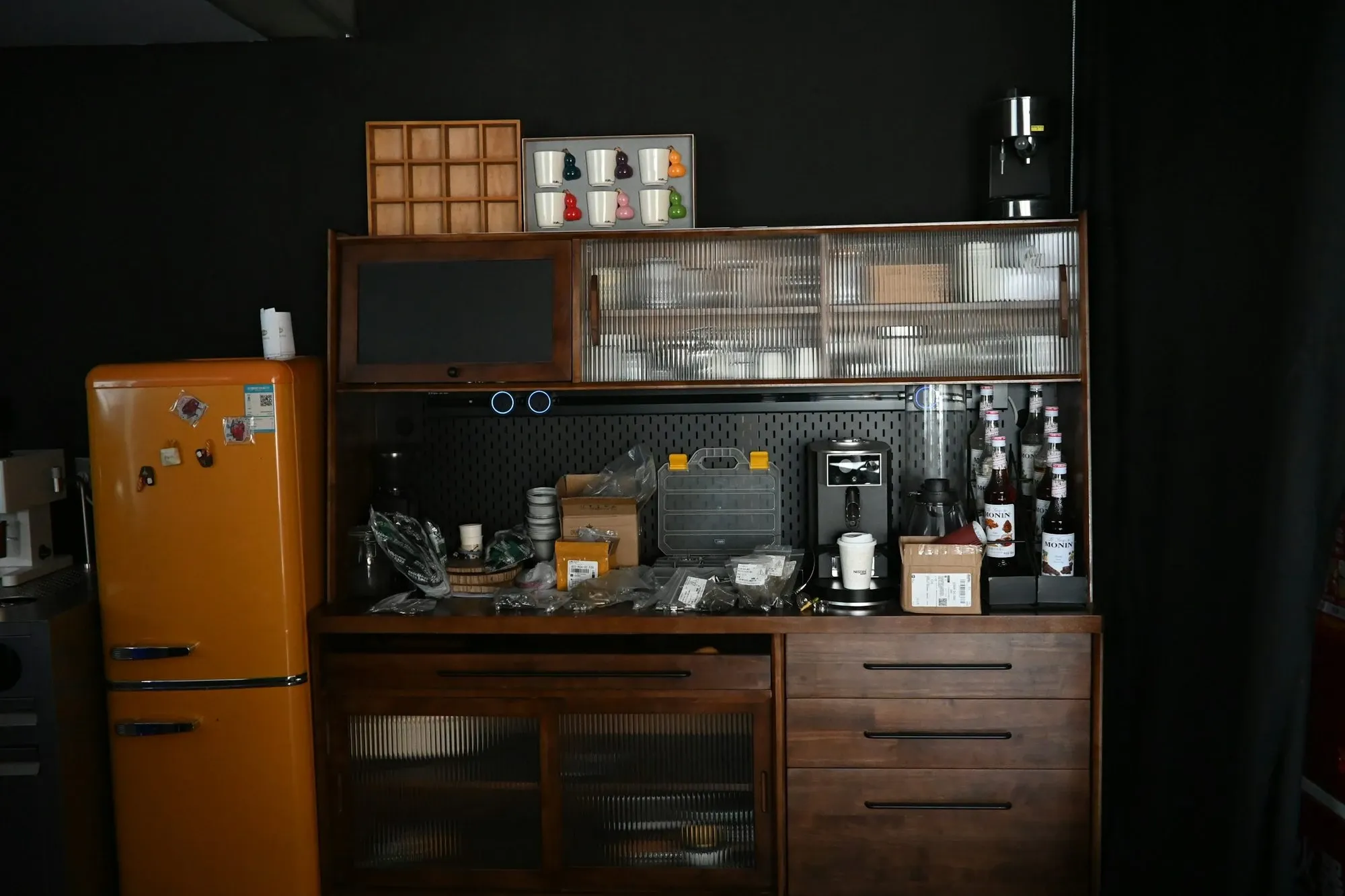 Coffee bar with a mini fridge beside a wood cabinet