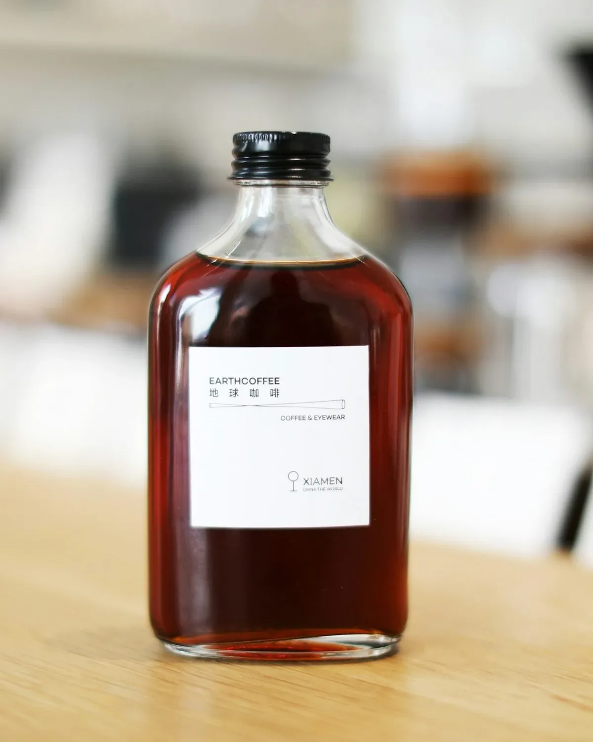 Glass bottle of syrup with a handwritten label on a wooden table