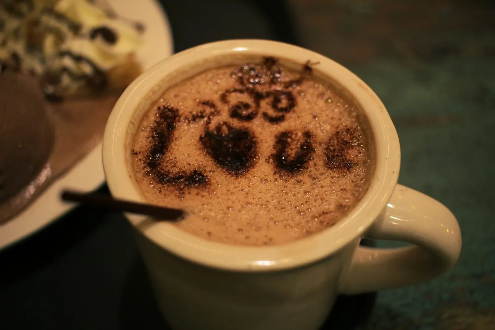 Mug of hot chocolate with the word Love stenciled on the foam in cocoa powder
